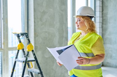 Güvenlik kasklı teknik uzman kadın inşaat işinde çalışıyor. Ciddi endüstriyel kadın mühendis müfettiş müfettişi belgeli mimar. İnşaat endüstrisi