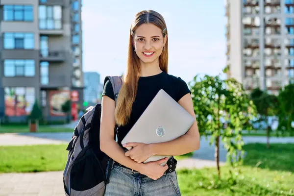 stock image Portrait young smiling female college student holding laptop computer outdoor, modern urban background. Education, technology, training, 17, 18 years age youth concept