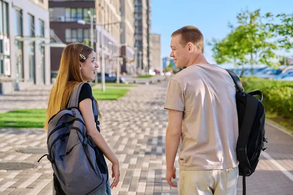 stock image Talking walking friends, guy and girl, back view, college students walking together along street of modern city. Youth 18-20 years old, friendship, communication, urban lifestyle concept