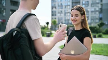 Arkadaşlar, öğrenciler, gülümseyen, gülen, gülen gençler, genç kızlara akıllı telefon ekranı gösteren genç adam, modern şehir, şehir geçmişi. Yaşam tarzı, gençler, üniversite gençlik hayatı konsepti