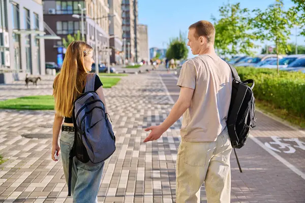 Yürüyen arkadaşlar, erkek ve kız, arka plan, kolej öğrencileri modern şehrin caddelerinde birlikte yürüyor. Gençlik 18-20 yaş arası, arkadaşlık, iletişim, kentsel yaşam tarzı kavramı