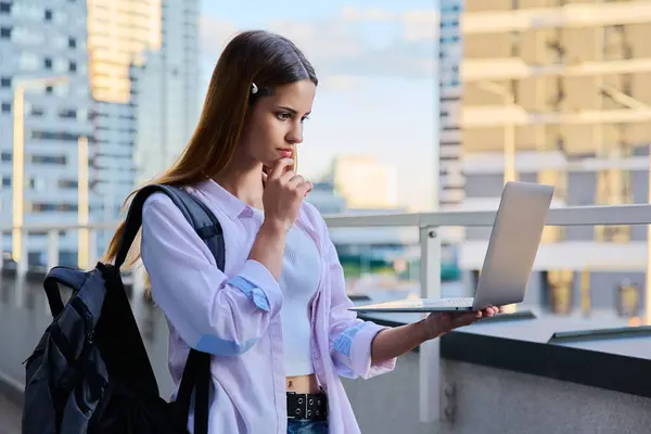 stock image Young attractive female college student using laptop computer outdoor, modern urban background. Education, technology, training, 17, 18 years age youth concept