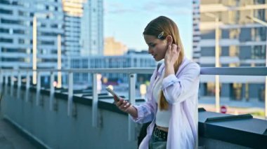 Akıllı telefon kullanan genç bir kadın, modern şehir geçmişi. Ergen öğrenci gezmek için mobil uygulama uygulamaları kullanarak mesajlaşıyor. Teknoloji İnternet Eğitim Gençlik Usulü