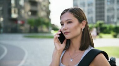 Dışarıda telefonla konuşan genç bir kadın, yüz yüze, şehir tarzı. Teknoloji, iletişim, yaşam tarzı, gençlik kavramı