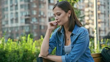 Dışarıda bankta oturan endişeli, üzgün, üzgün genç kadın. Zorluklar, sorunlar, akıl sağlığı, stres, depresyon, gençlik kavramı