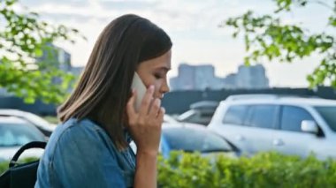 Genç pozitif gülümseyen bir kadın telefonda konuşuyor, profil görüntüsü, sokak tarzı. Teknoloji, iletişim, yaşam tarzı, gençlik kavramı