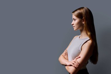 Profil görüntüsü, çapraz kollu başarılı gülümseyen genç kadın, kopya uzay gri stüdyo arka planı, reklam metni için alan. Eğitim hizmetleri insanları kavramı