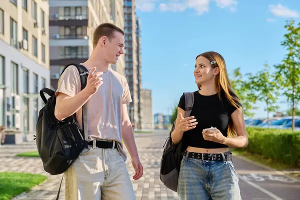 stock image Talking walking friends, guy and girl, college students walking together along street of modern city. Youth 18-20 years old, friendship, communication, urban lifestyle concept