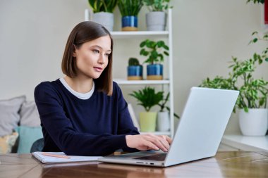 Genç bir kadın bilgisayar laptopunu klavyede yazan, çalışan, ciddi bir genç kız için kullanıyor. Teknoloji, eğitim, eğitim, gençlik kavramı