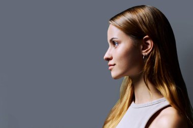 Profildeki portre, gri arka plan fotokopisinde kızıl saçlı güzel, gülümseyen genç bir kadın. Moda düşkünü bir genç kız. Güzellik ve sağlık eğitimi hizmetleri sunar.