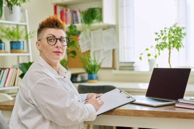 Ofiste elinde not panosuyla gülümseyen kadın psikoterapistin portresi. Profesyonel zihin terapisti psikolog sosyal hizmet görevlisi kameraya bakıyor. Sağlık hizmetleri, tedavi