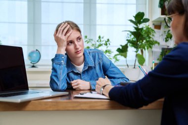 Genç ve üzgün bir bayan hasta profesyonel bir terapistle konuşuyor. Psikolog psikoterapist danışmanıyla terapi gören liseli bir kız. Psikolojik sağlık