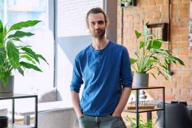 Sakallı, gülümseyen, kendine güvenen yakışıklı bir adamın fotoğrafı. Kameraya bakıyor. Yaşam tarzı, genç, modern, 30 'lu yaşların modası.