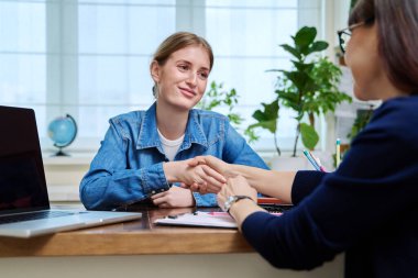 Gülümseyen genç bir bayan hasta profesyonel zihinsel terapistle konuşuyor. Psikolog psikoterapist danışmanıyla terapi gören liseli bir kız. Tedavi desteği
