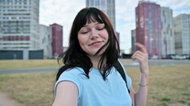 Selfie manzaralı, gülen genç bir kadın, webcam 'de konuşuyor, modern şehir gökdelenleri, şehir tarzı. Mutlu güzel kadın blogger vlogger etkileyicisi blogu kaydediyor. Güzellik, gençlik, yaşam tarzı konsepti