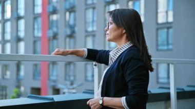 Dışarıda gözlüklü, güzel, pozitif, olgun bir kadının portresi. Gülümseyen orta yaşlı, saçları rüzgarda uçuşan ve kameraya bakan bir kadın. Yaş, sağlık, güzellik, yaşam tarzı, kariyer, 40 'lı yaşlar