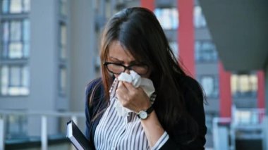 Açık havada peçeteye öksüren olgun bir kadın. Mevsimsel alerjiler, bulaşıcı hastalıklar, soğuk algınlığı, virüs, sağlık hizmeti konsepti