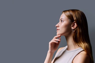Profildeki portre, gri arka plan fotokopisinde kızıl saçlı güzel, gülümseyen genç bir kadın. Moda düşkünü bir genç kız. Güzellik ve sağlık eğitimi hizmetleri sunar.