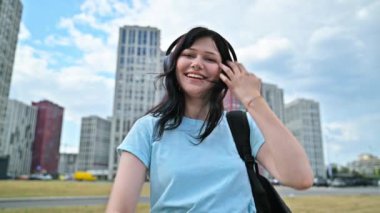 Kulaklıklı genç, kendine güvenen bir kadın, şehir dışındaki internet kamerasından konuşuyor. Kadın blogger vlog kaydedicisi vlog, öğrenci işçisi çevrimiçi konuşuyor, uzaktan görüntülü konferans görüşmesi