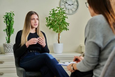Kadın psikiyatrist psikologla terapi toplantısında gülümseyen mutlu, neşeli genç kadın hasta. Psikoloji, psikoterapi, tedavi yardım desteği, gençlik akıl sağlığı