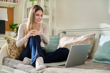 Evde dizüstü bilgisayarı olan genç bir kadın video görüşmesi yapıyor. Sosyal ağlarda iş arkadaşlarıyla sohbet eden bir bayan çevrimiçi olarak bilgisayar başında çalışan serbest çalışan bir öğrenci.