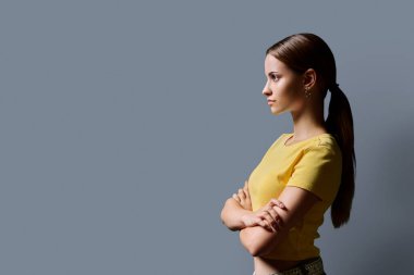 Profil bakış açısı, kendine güvenen başarılı kolları çapraz genç kız, kopya uzay gri stüdyo arka planı, reklam metni için alan. Eğitim hizmetleri insanları kavramı