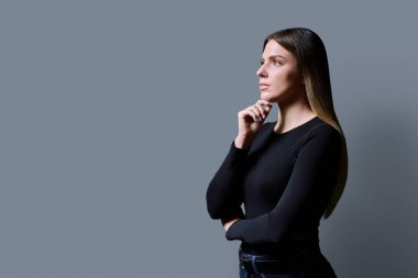 Profil görüntüsü, gri arka planda kendine güvenen genç bir kadın, kopyalama alanı. Bayan öğrenci bilgi metninin reklamını yapmak için yer arıyor. Gençlik, eğitim hizmetleri sağlık güzellik işi