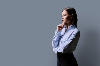 Gri stüdyo geçmişinde genç ciddi iş kadınının profil portresi. Taraf arayan kendine güvenen bir kadın, reklam metni için alanı kopyalayabilir. İş hizmetleri eğitimi güzellik sağlık hizmetleri