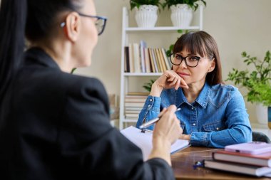 Profesyonel bir terapistle terapide olan orta yaşlı bir kadın hasta. Kadın psikoterapist psikolog, sosyal hizmet görevlisi hastayla konuşuyor. Psikoloji psikoterapi hizmetleri tedaviye yardımcı oluyor