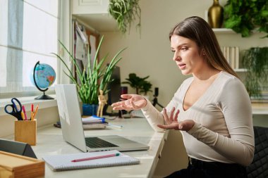 Üniversitede okuyan genç bir kız bilgisayar kullanarak evde oturup görüntülü konuşma yapıyor. İnternet üzerinden uzak dersler eğitim eğitimi kavramını değiştiriyor