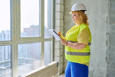 Güvenlik kasklı teknik uzman kadın inşaat işinde çalışıyor. Kendine güvenen endüstriyel kadın mühendis müfettişi müfettiş müteahhit mimarı planlar çizen planlar çizen bir mimar