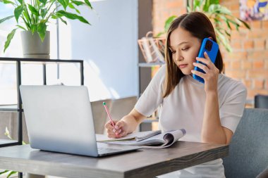 Genç bir kadın laptopuyla masada oturmuş birlikte çalıştığı kafede cep telefonuyla konuşuyor. Sınava hazırlanan bayan üniversite öğrencisi, serbest çalışan, uzaktan çalışan bir iş adamı.