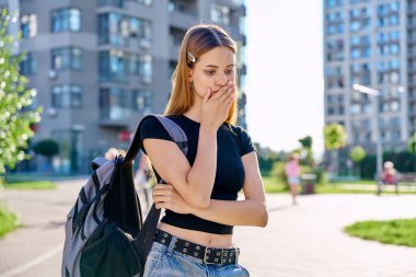 Mutsuz, gergin, sırt çantalı, açık hava, şehir geçmişi olan üniversiteli kız. Olumsuz duygular, eğitim, yaşam tarzı, zihinsel sorunlar, gençlik kavramı