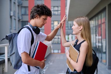 İki arkadaş öğrencisiyle tanışacak. 18-19 yaşlarındaki genç kız ve erkek. Açık havada el sıkışıyorlar. Yaşam tarzı, gençlik, yaşam konsepti