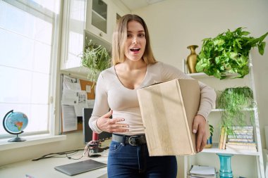 Evde alışveriş yapan genç bir bayan, içinde online alışverişler olan karton kutuları açıyor. Mutlu yirmili yaşlarda kutuları açan kadın tüketiciler. Postayla teslimat, çevrimiçi mağaza, e-alışveriş konsepti