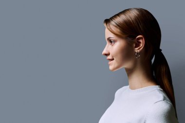 Profildeki portre, gri arka plan fotokopisinde kızıl saçlı güzel, gülümseyen genç bir kadın. Moda düşkünü bir genç kız. Güzellik ve sağlık eğitimi hizmetleri sunar.