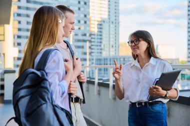 Bir grup üniversite öğrencisi bayan öğretmen, akıl hocası, koç, yönetmen, lider ve sosyal hizmet uzmanıyla konuşuyor. Eğitim, öğrenim, akıl hocalığı, koçluk, danışmanlık, gençlik eğitimi kavramı