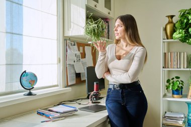 Genç bir kadın akıllı telefondan sesli mesaj kaydediyor. Evde, telefonun yanında konuşarak sesli mesaj gönderiyor. Teknoloji, iletişim, sesli mesaj, yaşam tarzı, gençlik kavramı