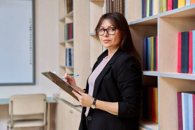 Kütüphane ofisinde dosyası olan ciddi bir kadının portresi orta yaşlı kadın öğretmen akıl hocası, psikolog terapist. Profesyonel eğitim, zihinsel uzman, insanlar