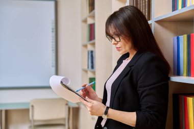 Kütüphane ofisinde dosyası olan ciddi bir kadının portresi orta yaşlı kadın öğretmen akıl hocası, psikolog terapist. Profesyonel eğitim, zihinsel uzman, insanlar