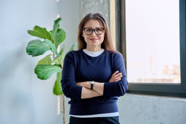 Kendine güveni tam, olgun, güzel bir kadın çapraz kollarla kameraya bakıyor. İş, iş, başarı, güven, olgun insanlar konsepti