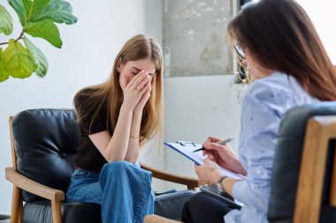 Üzgün üzgün, terapi seansında psikolog psikolog muayenehanesindeki genç kadın hasta. Ruh sağlığı, psikoloji psikoterapisi, sosyal hizmetler, tedavi desteği gençlik kavramına yardım