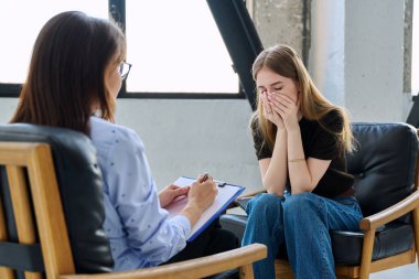 Üzgün üzgün, terapi seansında psikolog psikolog muayenehanesindeki genç kadın hasta. Ruh sağlığı, psikoloji psikoterapisi, sosyal hizmetler, tedavi desteği gençlik kavramına yardım