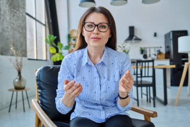 İnternet portresi orta yaşlı kadın öğretmen psikolog iş kadını blogger vlogger ofis. Konuşan kadın video konferansına bakıyor, online toplantı, oturum dersi, blog vlog kaydı