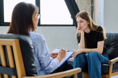 Üzgün üzgün, terapi seansında psikolog psikolog muayenehanesindeki genç kadın hasta. Ruh sağlığı, psikoloji psikoterapisi, sosyal hizmetler, tedavi desteği gençlik kavramına yardım