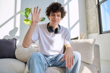 Webcam görüntüsü, genç üniversite öğrencisinin web kamerasına bakması, online görüşme, internet görüntülü sohbet konferansı. Kıvırcık saçlı yakışıklı erkek blogger vlogger kayıt videosu evde