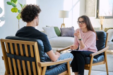Orta yaşlı kadın psikolog psikoterapist terapist genç erkek hasta ile çalışan zihinsel terapist. Psikoloji psikoterapi sosyal sağlık hizmetleri tedavi destek konsepti
