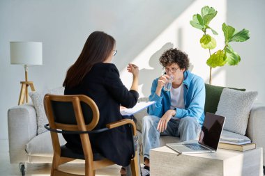 Akıl hastanesindeki genç adam profesyonel psikologla konuşuyor. Hasta ile çalışan kadın psikiyatrist danışmanı. Psikoloji psikiyatri tedavi desteği gençlere yardımcı oluyor