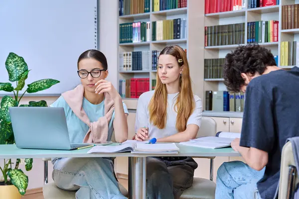 Bir grup öğrenci lise çağında sınıf kütüphanesinde birlikte oturmuş sınavlara hazırlanıyorlar. Eğitim, öğrenme, bilgi, gençlik kavramı