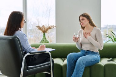 Psikoterapist psikolog, sosyal psikolog, profesyonel uzman ofisinde terapi gören üzgün, genç bir kadın. Gençlik psikolojisinin zihinsel sağlığı sorunları, danışmanlık